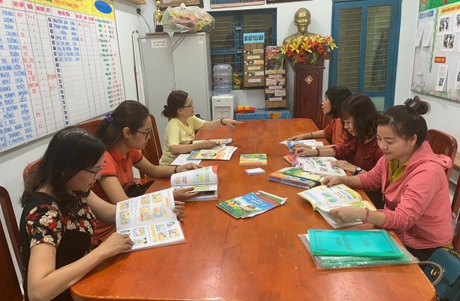 Giáo viên trường Tiểu học Nguyễn Thị Minh Khai, quận Gò Vấp nghiên cứu các bộ sách giáo khoa lớp 1. Ảnh: NTCC