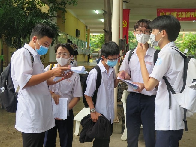 Thí sinh trao đổi bài sau khi đã kết thúc bài thi môn Toán tại điểm thi trường THPT Hiệp Bình, TP.HCM. Ảnh: PHẠM ANH