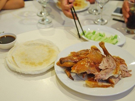 Thịt vịt quay ăn kèm bánh kẹp, hành tăm và nước tương ở Bắc Kinh, Trung Quốc.