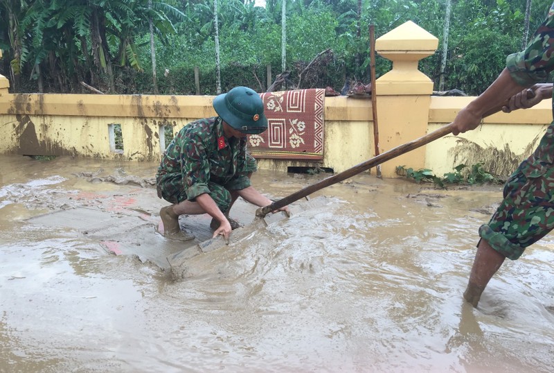 Quân đội giúp dân dọn sạch bùn đất vùng lũ - ảnh 1