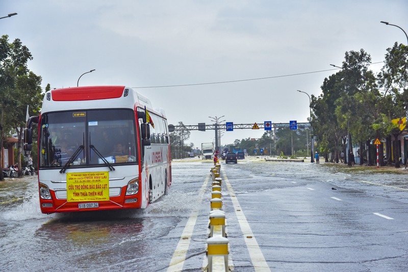 Nước ngập sâu, máy cày kiếm tiền triệu trên Quốc lộ 1 - ảnh 1