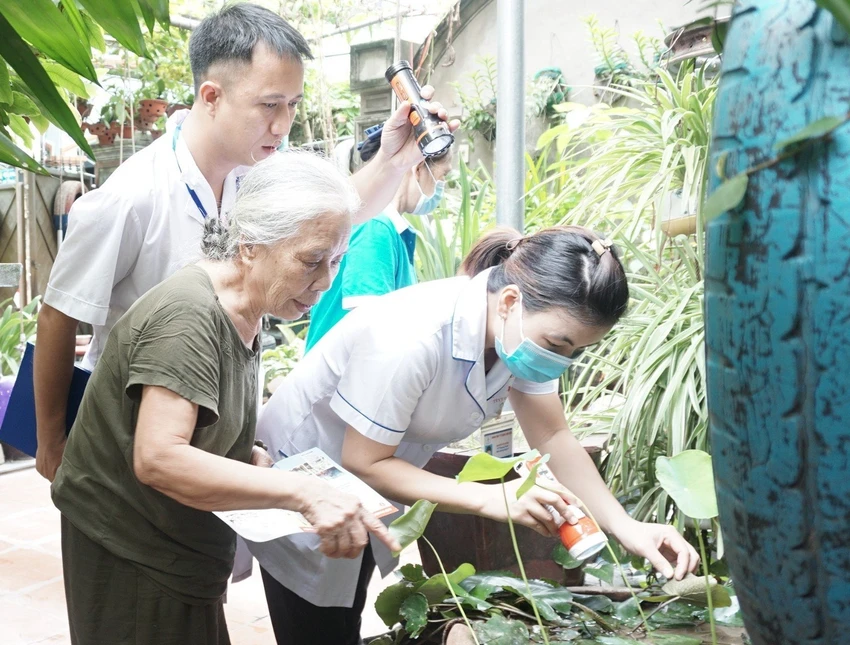 Cán bộ y tế hướng dẫn người dân cách diệt lăng quăng, bọ gậy phòng chống sốt xuất huyết. Ảnh: SKĐS ảnh 1 sot-xuat-huyet.jpg