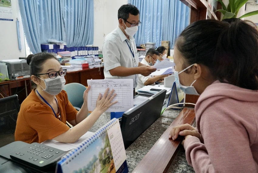 Cán bộ phường Bình Hưng Hòa A, quận Bình Tân hướng dẫn người dân làm hồ sơ, thủ tục hành chính. Ảnh: BẢO PHƯƠNG P2_chinh_ttam.jpg