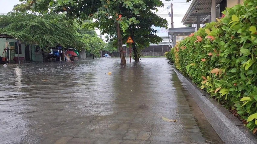 Nước tràn lên hết vỉa hè, "đe doạ" nhà dân. Ảnh: MINH TRƯỜNG. da nang ngap lut kia.jpg