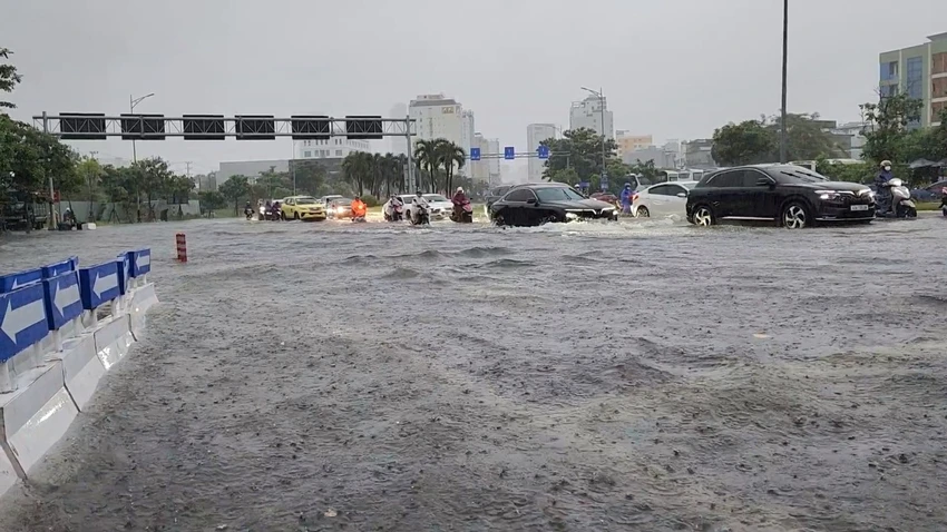 Ngã tư Phạm Văn Đồng - Ngô Quyền biến thành biển nước gây khó khăn cho người tham gia giao thông. Ảnh: MINH TRƯỜNG. da nang ngap lut pham van dong.jpg