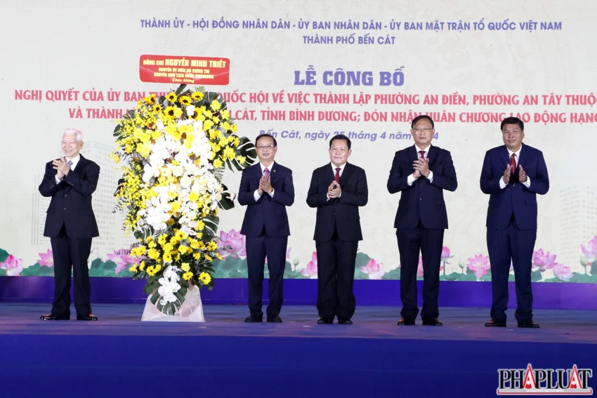 Ông Nguyễn Minh Triết, nguyên Chủ tịch nước tặng hoa chúc mừng chính quyền nhân dân TP Bến Cát. Ảnh: LÊ ÁNH