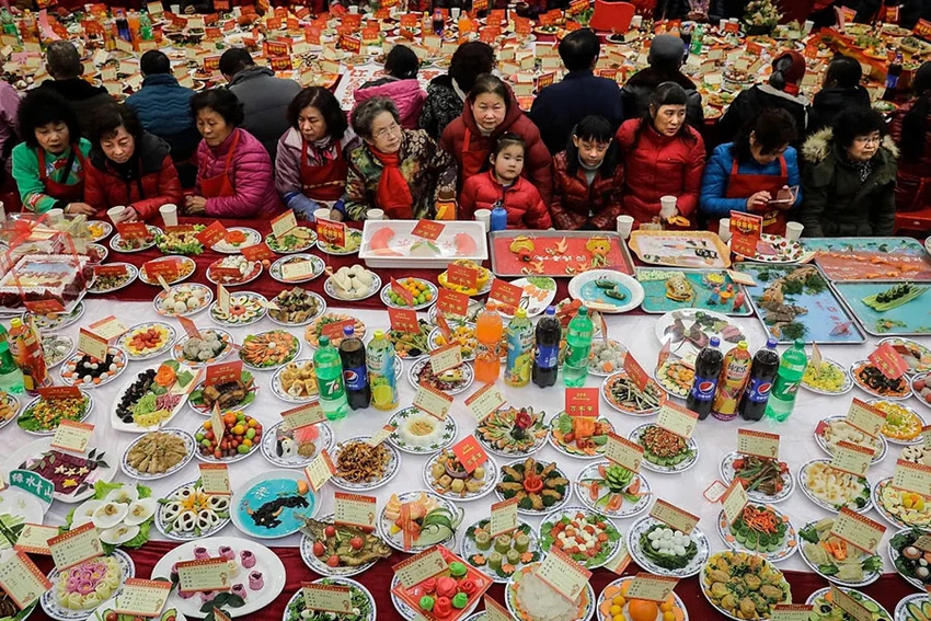 Cư dân khu phố ngồi quanh một bàn ăn tại TP Vũ Hán, tỉnh Hồ Bắc (Trung Quốc) đón tết Nguyên đán. Ảnh: CNN