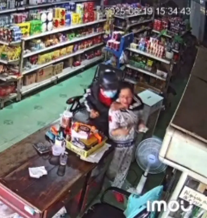 Nữ chủ tiệm tạp hoá bị hung thủ dùng dao khống chế. Ảnh: Cắt từ clip. nữ chủ tiệm...jpg