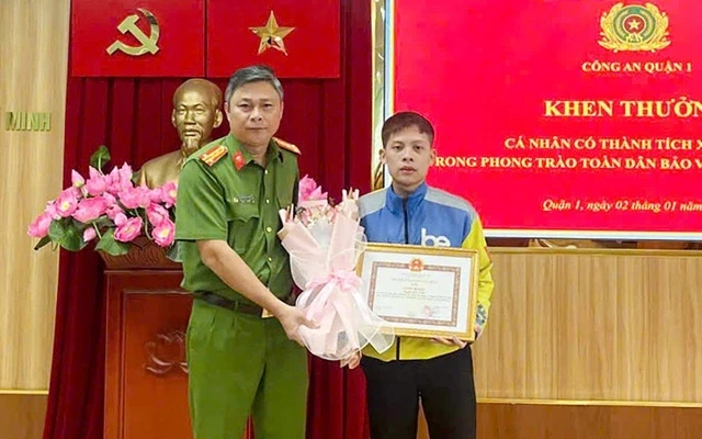 Chiều 2-1, Đại tá Nguyễn Hải Phước - Trưởng Công an quận 1 (TP.HCM) trao thư khen cho cho anh Hà Hữu Vinh, tài xế xe công nghệ, người đã dũng cảm can ngăn hai vợ chồng đánh người đi đường ở quận 1. Ảnh: CA cach-lam-nguoi-tot.jpg