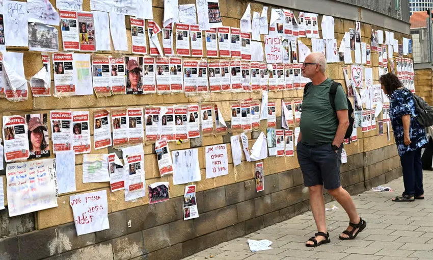 Người dân ở Tel Aviv, Israel nhìn vào những tờ thông báo tìm người bị Hamas bắt làm con tin. Ảnh: DEBBIE HILL/UPI ẢNH 1_P16 CON TIN.png