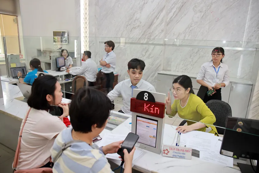 Cán bộ Trung tâm phục vụ hành chính công phường Sài Gòn giải quyết thủ tục cho người dân. Ảnh: NGUYỆT NHI Bộ trưởng Bộ Nội vụ: Rà soát toàn bộ chính sách tiền lương, phụ cấp