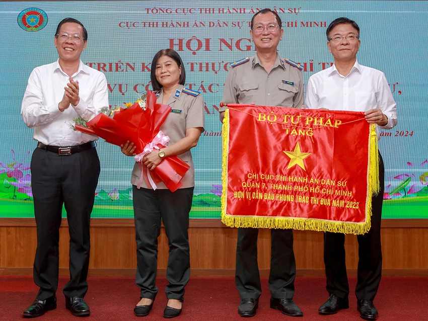 Bộ trưởng Bộ Tư pháp Lê Thành Long (bìa phải) và Chủ tịch UBND TP.HCM Phan Văn Mãi (bìa trái) trao cờ thi đua ngành tư pháp cho đại diện Chi cục THADS quận 7 tại Hội nghị triển khai công tác năm 2024 của Cục THADS TP.HCM. Ảnh: NGUYỆT NHI 22-Anh-1.jpg