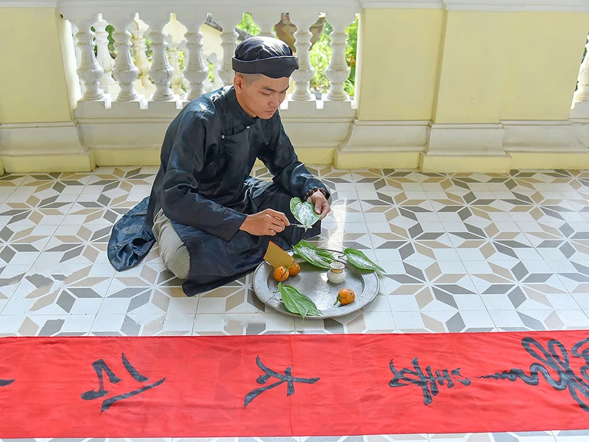 Anh Trần Hữu Phú viết bùa nêu vào ngày 15 tháng Chạp. Ảnh: TRẦN PHÚ 34-Anh-3.jpg