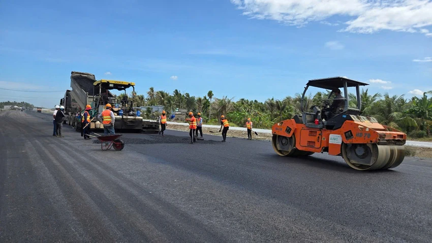 Phần đường dẫn hai đầu cầu đang thực hiện thảm bê tông, dự kiến hoàn thành toàn bộ phần tuyến phía Bến Tre trước 30-6. Ảnh: V.LONG cau-rach-mieu-2-.jpg