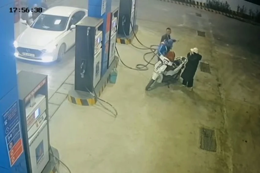 Nhân viên đang đổ xăng vào xe máy cho một phụ nữ thì bị người đàn ông đi trên xe hơi quay lại tấn công. Ảnh cắt từ video clip. danh-nha-vien-cay-xang.jpg
