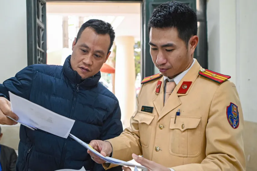 Cán bộ CSGT hướng dẫn người dân thủ tục đổi giấy phép lái xe. Cục CSGT khuyên người dân đổi giấy phép lái xe trực tuyến