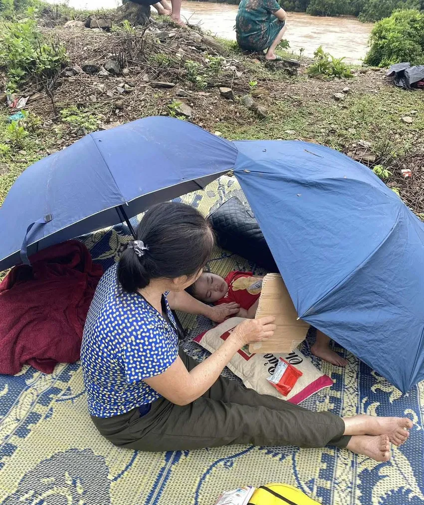 Một người dân ôm con lên núi lánh nạn. d- chuyen.jpg