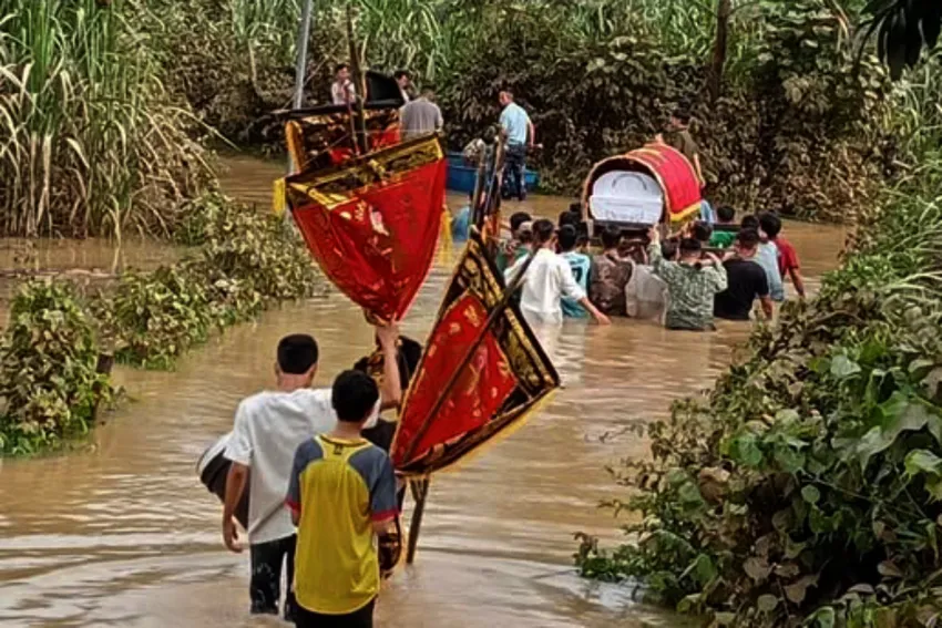 Chính quyền địa phương và người thân, người dân đưa quan tài vượt nước lũ đi mai táng. Ảnh: CTV. nguoi-chet.jpg