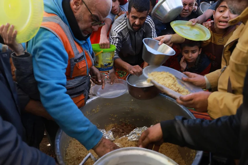 Người dân nhận thực phẩm ở TP Rafah (phía nam Dải Gaza, Palestine) hôm 30-11. Ảnh: AFP Người dân Gaza lâm cảnh đói kém, phải đào đống đổ nát để tìm thức ăn sót lại