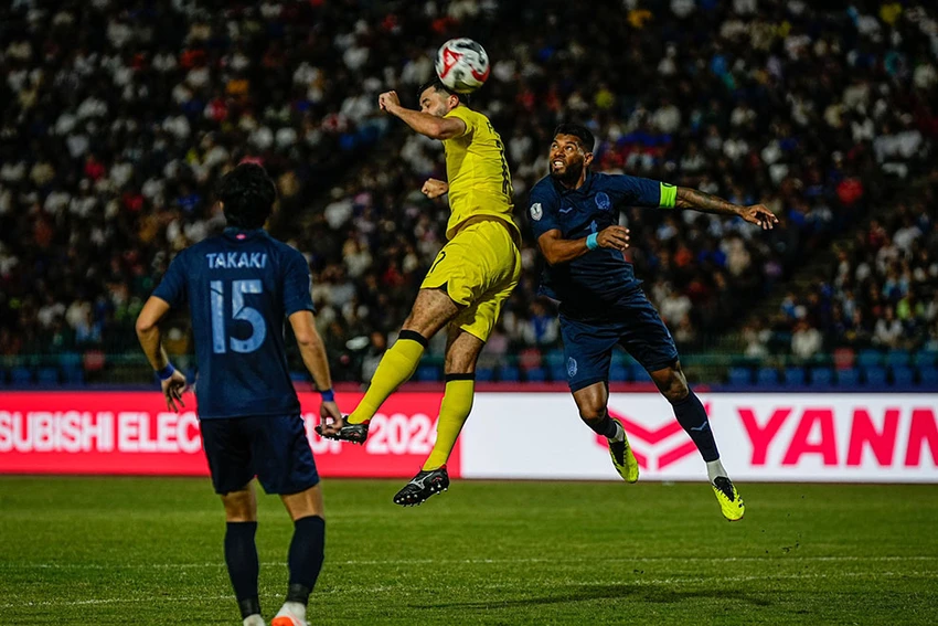 Trung vệ Mohammed Faeez Khan và Takaki Ose của tuyển Campuchia đối đầu với Malaysia. Ảnh: CCT. AFF Cup 2024