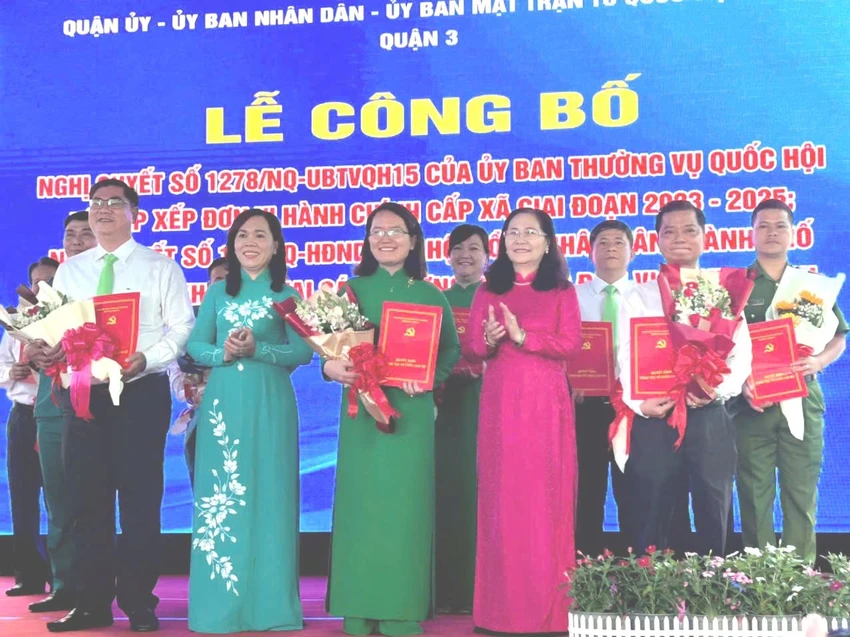 Chủ tịch HĐND TP.HCM Nguyễn Thị Lệ và Bí Quận ủy quận 3 tặng hoa, trao quyết định cho các cán bộ phường mới. Ảnh: HỒNG THẮM sắp xếp đơn vị hành chính (1).jpg