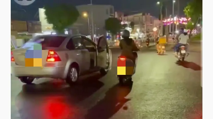 Tài xế vẫn cho xe ô tô chạy khi cửa xe còn mở, người phụ nữ cũng tiếp tục đuổi theo. Ảnh cắt từ clip Clip ghi cảnh một phụ nữ đi xe máy dùng gậy đập kính ô tô giữa đường ở TP Cao Lãnh gây xôn xao mạng xã hội.