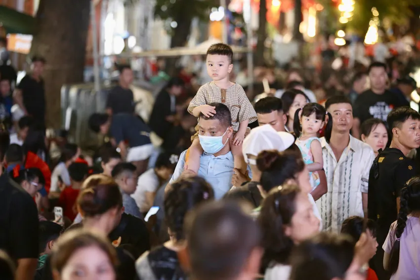 Nhiều em bé được bố mẹ bế đặt lên vai để giúp các bé nhìn được xa hơn. Phố đi bộ Hồ Gươm (Hoàn Kiếm) được coi là vị trí vàng để chiêm ngưỡng pháo hoa. Không gian thoáng rộng, nằm ngay bên hồ, kết hợp với nhiều nhà hàng, quán cà phê có tầm nhìn hướng mặt nước. Người dân có thể trải nghiệm vừa thưởng thức ẩm thực, vừa ngắm pháo hoa bừng sáng giữa trung tâm Thủ đô. Ảnh: HOÀNG GIANG HoGuom3.jpg