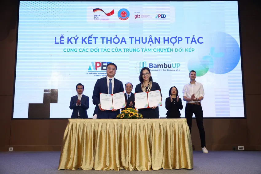 Ông Nguyễn Đức Trung - Cục phó Cục Phát triển Doanh nghiệp tư nhân và Kinh tế tập thể (APED) và bà Nguyễn Hương Quỳnh, Giám đốc điều hành BambuUP ký kết biên bản hợp tác. Ảnh: NGỌC DIỆP 2010.jpg