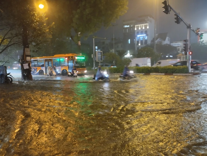 Trong cơn mưa lớn ở Hà Nội vào tối ngày 12-5, nhiều đường phố bị ngập. (Hình ảnh ghi nhận trên đường Láng, nhiều người phải dắt xe do nước ngập sâu) Mưa lớn ở Hà Nội