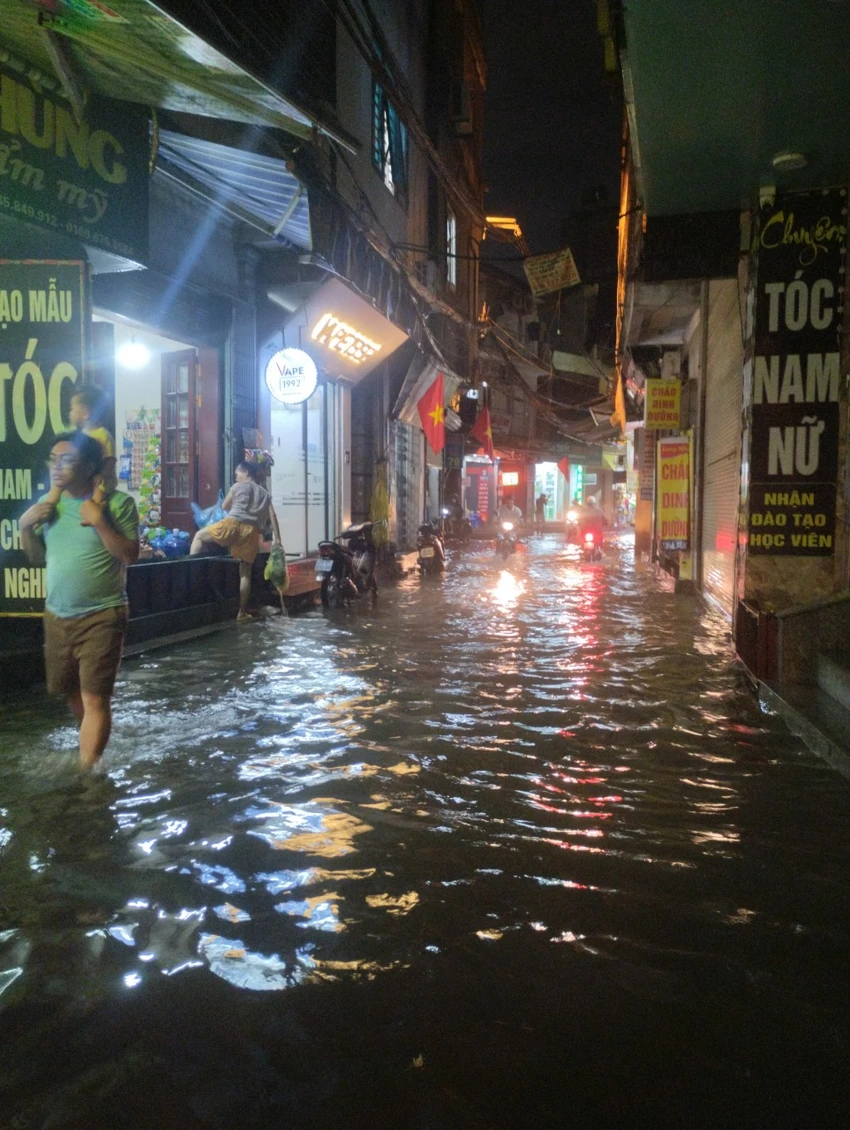 Một số hộ dân phải kê bàn ghế để tránh nước ngoài đường ngập vào nhà trên đường Phú Mỹ. ngap (3).jpg