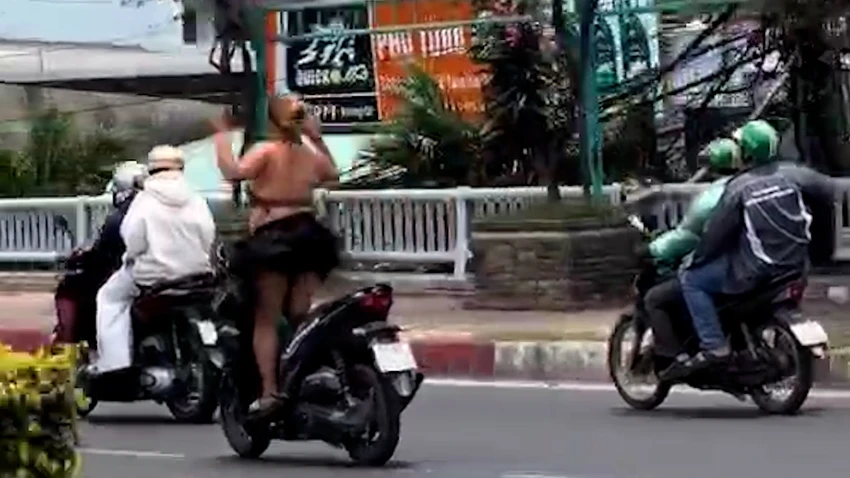 Hành vi của cô gái khiến người đi đường lo ngại. Ảnh cắt từ clip cong-an-xac-minh-clip-co-gai-chay-xe-may-buong-ca-hai-tay-gio-1-chan-len-troi-1.jpg