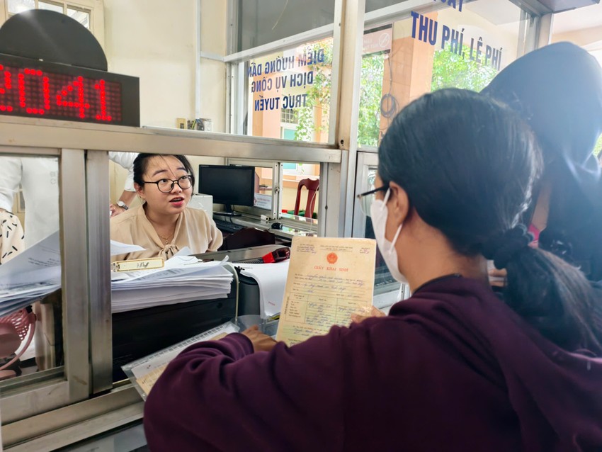 Các công chức làm việc tại Trung tâm phục vụ hành chính công xã Củ Chi tận tình hướng dẫn cho chị Nguyễn Ngọc Bảo Châu. Ảnh: NT xa-cu-chi-tap-trung-giai-quyet-thu-tuc-hanh-chinh-sau-sap-nhap (3).jpg