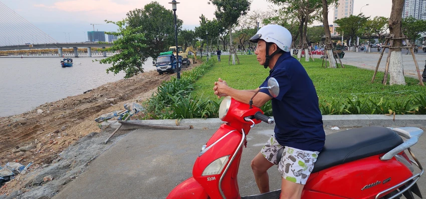 Người dân ra theo dõi việc xử lý đất đá, xà bần sau khi báo phản ánh. Ảnh: MINH TRƯỜNG. sông hàn