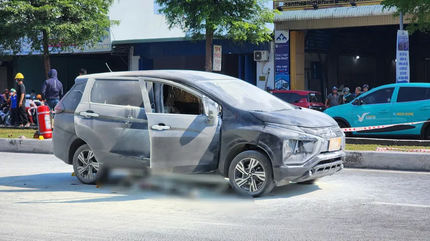 Chiếc xe ô tô bốc cháy cùng nạn nhân nằm dưới gầm xe. Ảnh: MINH TRƯỜNG. nan-nhan-tu-vong.jpg
