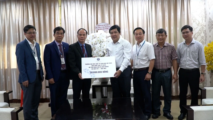 Ông Nguyễn Thái Bình, Phó Tổng biên tập báo Pháp luật TP.HCM (bên phải) đại diện nhận bảng biểu trưng số tiền quyên góp 50 triệu đồng của Trường ĐH Luật TP.HCM. dai-học-luat.jpg