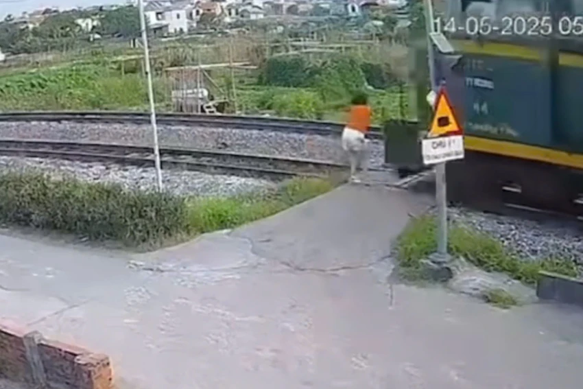 Người phụ nữ bị tàu hỏa húc văng khi đi qua đường ray. Ảnh chụp màn hình