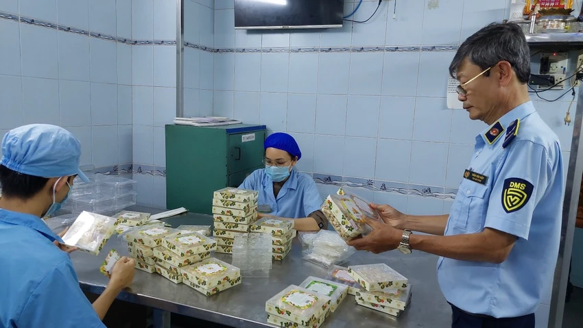 Cán bộ QLTT TP.HCM kiểm tra một cơ sở tại quận 3, đang đóng gói mứt nhưng không ghi xuất xứ, không hạn sử dụng, không nhãn hàng hóa theo quy định, không hóa đơn, chứng từ chứng minh nguồn gốc. Ảnh: QLTT TP.HCM giỏ quà tết