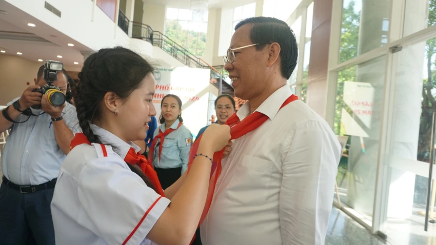 Học sinh thắt khăn quàng đỏ cho Chủ tịch Phan Văn Mãi trước khi buổi gặp gỡ diễn ra. Ảnh: NQ chuong-trinh-moi-chua-giam-tai-1.JPG