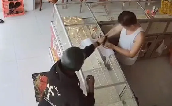 Nam thanh niên bất ngờ xịt hơi cay vào mặt chủ tiệm vàng, cướp vàng. (Ảnh được camera ghi lại). Bắt nam thanh niên xịt hơi cay vào mặt chủ tiệm vàng, cướp vàng