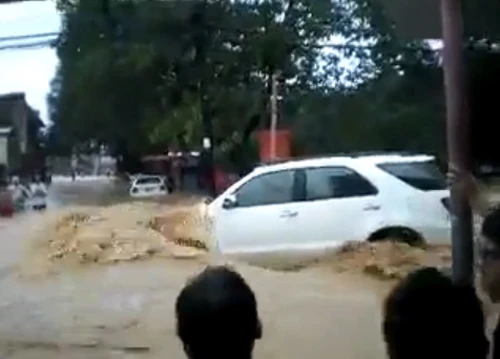Trên một con phố ở Philippines, chiếc SUV màu trắng không thể địch lại sức mạnh của dòng lũ cuồn cuộn đổ về. Người dân hai bên đường đành đứng xem vì không thể làm gì để trợ giúp. xe-6-2032-1380859096.jpg