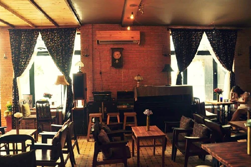 6. Vecchio cafe - Phạm Ngọc Thạch, quận 3 Mang đậm nét kiến trúc miền nam Italy, quán cafe Vecchio khiến bạn liên tưởng đến những ngôi nhà nhỏ xinh và cổ điển. Đằng sau cánh cửa quán là một không gian ấm cúng mang nét hoài cổ, những chiếc loa mặt võng cũ kỹ có từ thập niên 70 của thế kỷ trước, những chiếc tivi đen trắng, máy đánh chữ, bàn ủi con gà... Hàng đêm, thực khách sẽ được "phiêu" theo những ca khúc bất hủ bằng tiếng Anh, Việt và Italy như Yesterday, Top of the world, Saving all my love for you hay những tình khúc Quốc Bảo, Phạm Duy, Ngô Thụy Miên… dưới âm thanh du dương của piano, violin và guitar. Mang đậm nét kiến trúc miền nam Italy, quán cafe Vecchio khiến bạn liên tưởng đến những ngôi nhà nhỏ xinh và cổ điển. Đằng sau cánh cửa quán là một không gian ấm cúng và hài hòa của nghệ thuật sắp đặt mang nét hoài cổ với những chiếc loa mặt võng cũ kỹ có từ thập niên 70 của thế kỷ trước, những chiếc tivi đen trắng, máy đánh chữ, bàn ủi con gà... Ngoài những bản nhạc Italy nhẹ nhàng, hàng đêm quán còn thu hút thực khách với chương trình ca nhạc theo phong cách Acoustic. Thực khách sẽ được 'phiêu' theo những ca khúc bất hủ bằng tiếng Anh, Việt và Italy như Yesterday, Top of the world, Saving all my love for you hay những tình khúc Quốc Bảo, Phạm Duy, Ngô Thụy Miên& dưới âm thanh du dương của piano, violin và guitar.