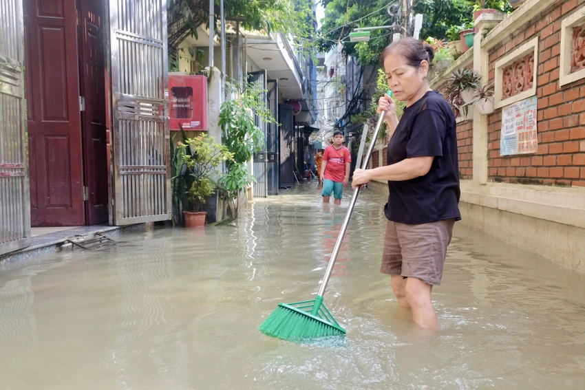 Bà Phạm Thị Hiển nỗ lực lùa rác ra xa. Ảnh: TT