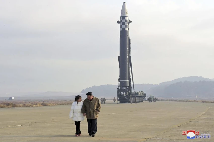 Hai cha con ông Kim Jong-un nắm tay đi thị sát bãi phóng tên lửa. Ảnh: KCNA