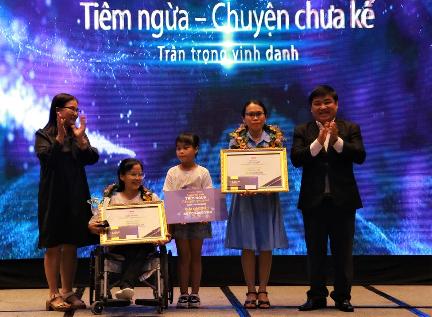 Tổng biên tập báo Tuổi trẻ Lê Thế Chữ và BS CKI Bạch Thị Chính, Giám đốc y khoa Hệ thống Trung tâm Tiêm chủng VNVC trao giải Đặc biệt cho hai tác giả. Ảnh: VÕ THƠ