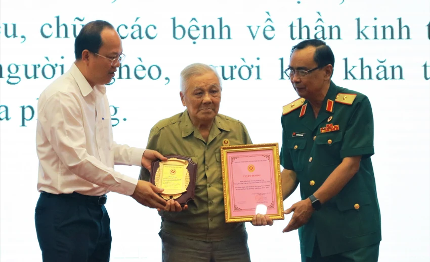Phó Bí thư Thành ủy TP.HCM Nguyễn Hồ Hải và Chủ tịch Hội Cựu chiến binh TP.HCM Nguyễn Minh Hoàng trao biểu trưng cho Cựu chiến binh, Nhà báo Trương Nguyên Tuệ. Ảnh: VÕ THƠ