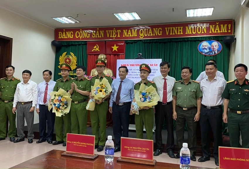 Bí thư Huyện ủy cùng lãnh đạo UBND huyện Vĩnh Cửu tặng hoa và phần thưởng cho các đơn vị tham gia bắt giữ nhanh nghi can gây ra vụ cướp tài sản. Ảnh: VH.