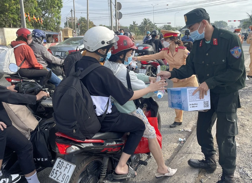 Lực lượng công an phát nước suối cho người dân về quê đón Tết Nguyên đán 2023. Ảnh: VH.