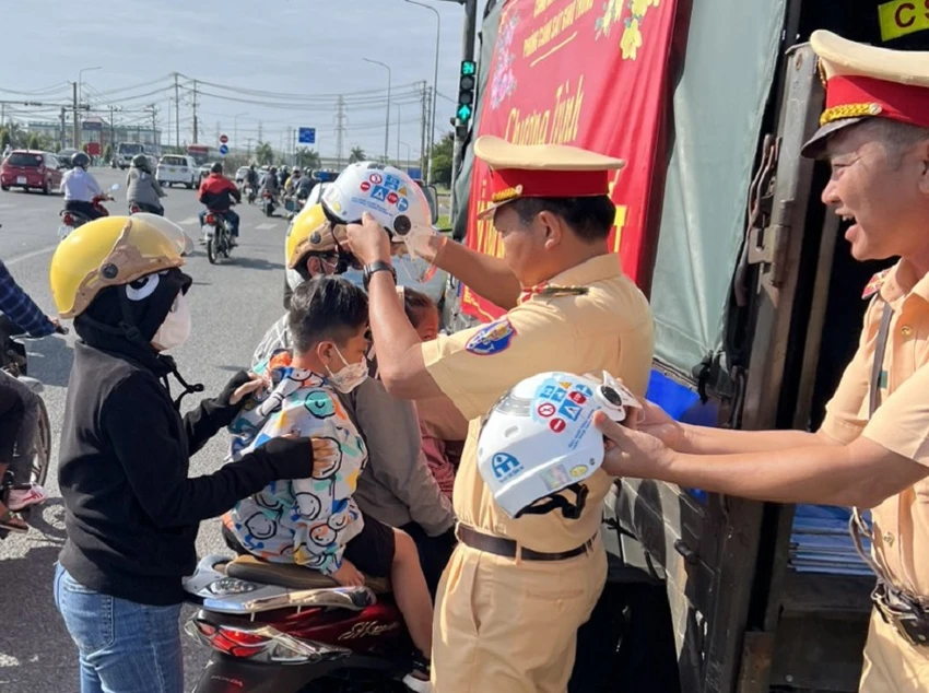 CSGT Công an tỉnh Đồng Nai phát mũ bảo hiểm cho người dân. Ảnh: VH.