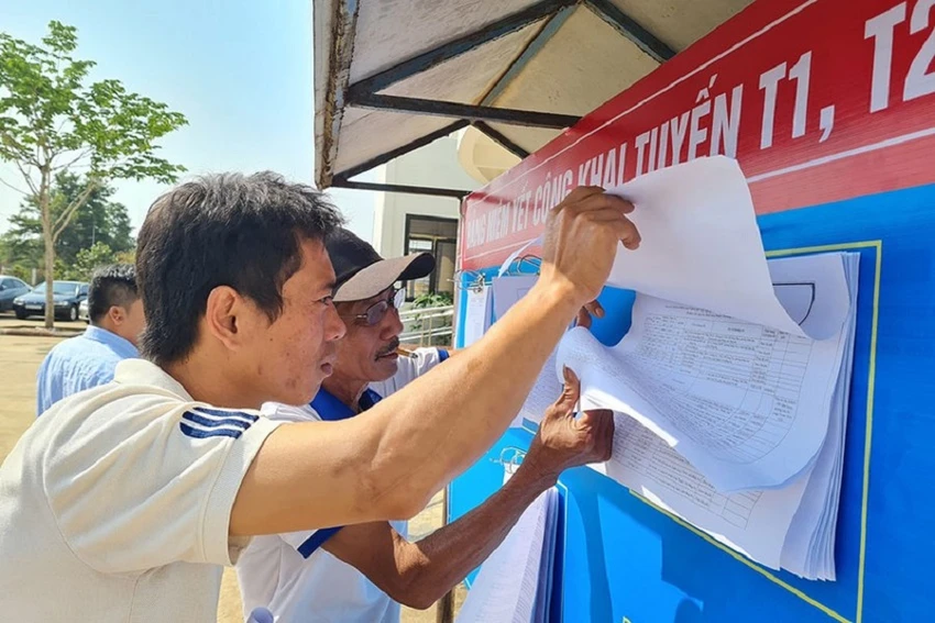 Người dân xem thông tin niêm yết về dự án T1, T2. Ảnh: VŨ HỘI Người dân xem thông tin niêm yết về dự án T1, T2. Ảnh: VŨ HỘI