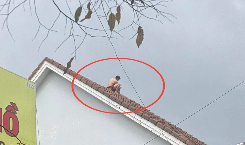 Nam thanh niên trên nóc nhà. Ảnh: CN